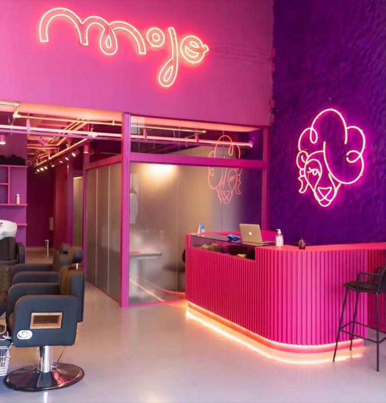 Interior da loja MOJO, com letreiro de neon e recepção